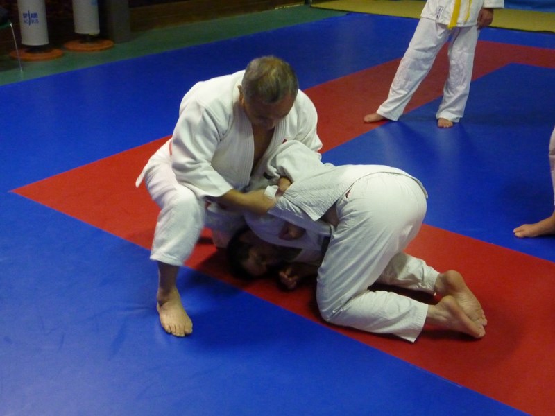 Tori glisse sa main gauche sous le bras d'uke et saisit le judogi grace